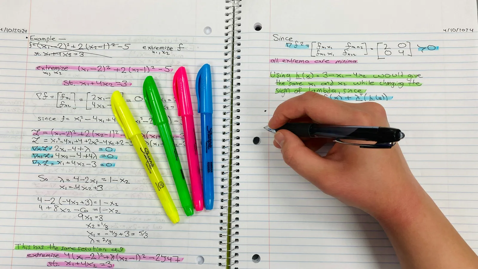 Revision notes in a notebook, marked up with bright highlighters