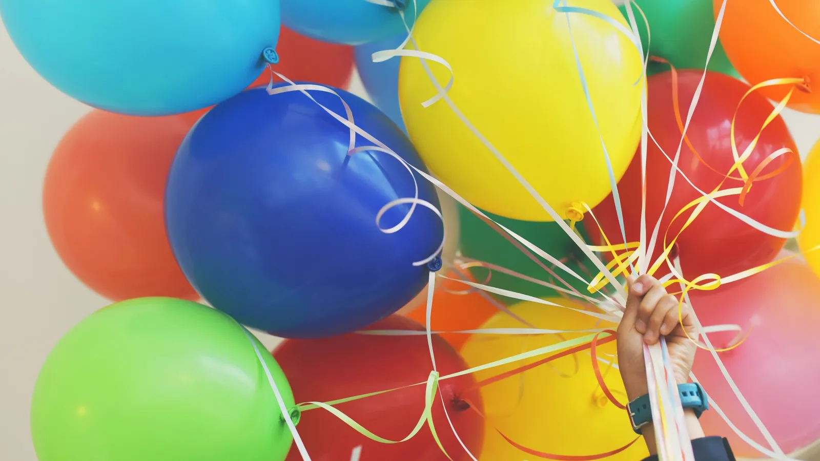 A bunch of bright balloons in red, yellow, blue and green