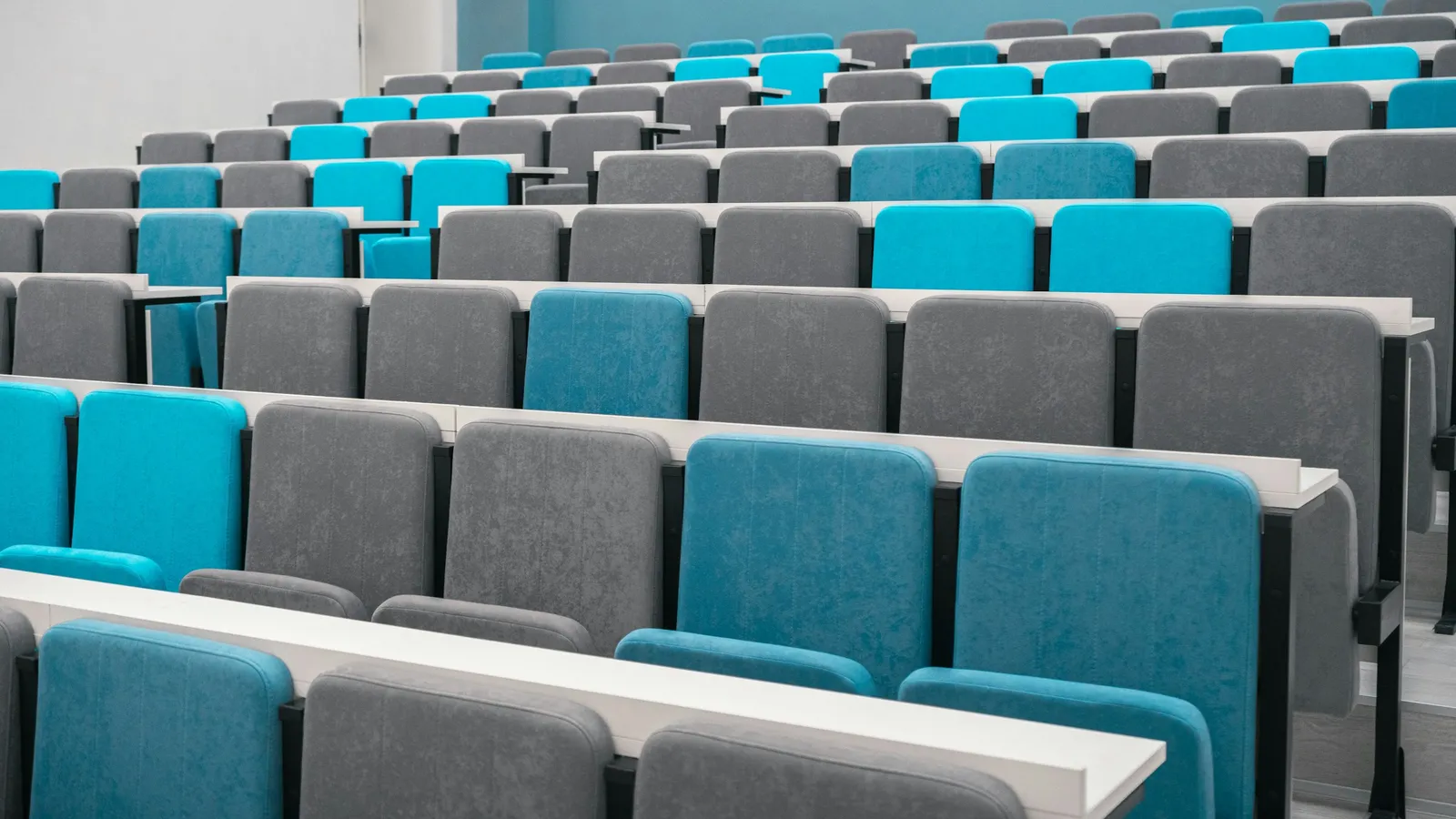Rows of turquoise and grey seats in a lecture hall