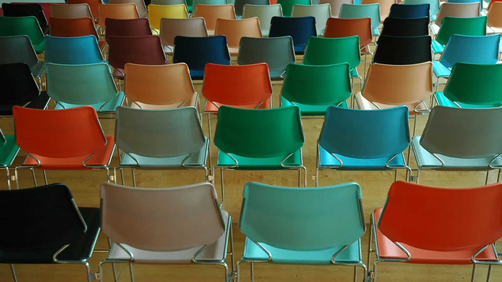 Rows of chairs in red, green and blue, waiting for a class